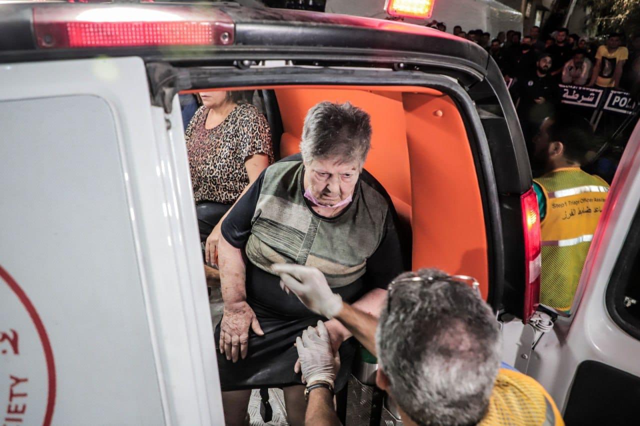 طواقم الإسعاف تنقل إمرأة فلسطينية مسنة أصيبت في قصف طيران الاحتلال لكنيسة الروم الأرثوذكس في غزة 